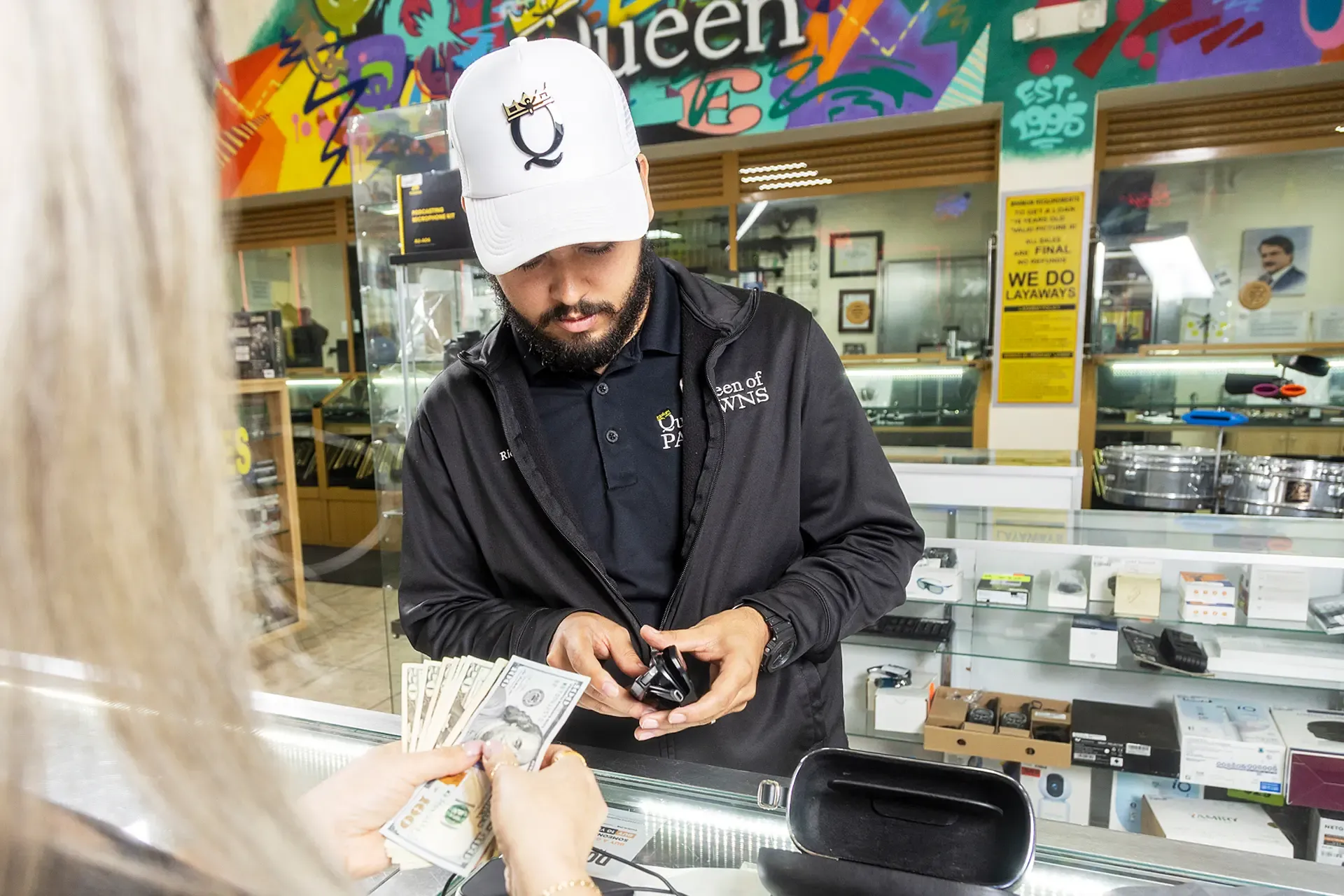 Queen of Pawns team member helping a customer at the counter